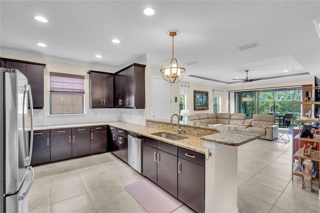 4610 Alexandria Ct, Palmetto, FL 34221 - kitchen featuring appliances with stainless steel finishes, a sink, ceiling fan with notable chandelier, a peninsula, and open floor plan