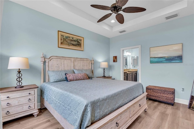 4610 Alexandria Ct, Palmetto, FL 34221 - bedroom with a raised ceiling, ensuite bath, baseboards, wood finished floors, and visible vents