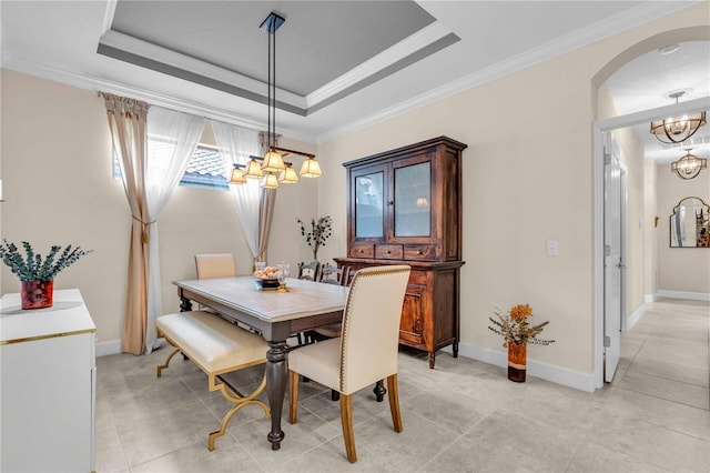 4610 Alexandria Ct, Palmetto, FL 34221 - dining area featuring a notable chandelier, arched walkways, baseboards, a tray ceiling, and ornamental molding