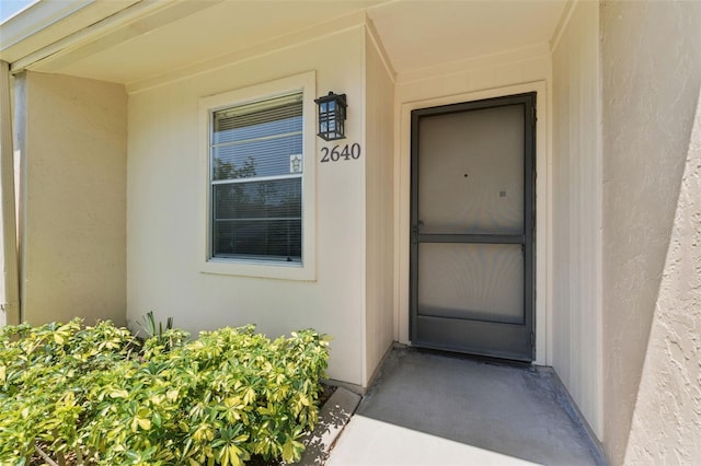 property entrance with stucco siding