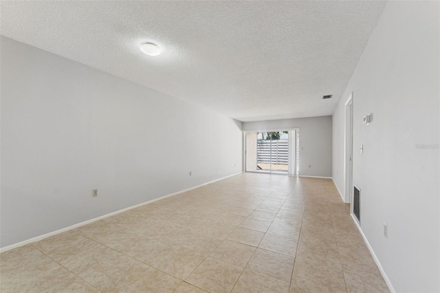 unfurnished room with visible vents, a textured ceiling, and light tile patterned floors