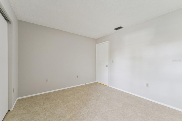 empty room with baseboards and visible vents