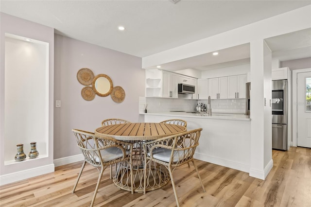 dining room featuring recessed lighting, baseboards, and light wood finished floors