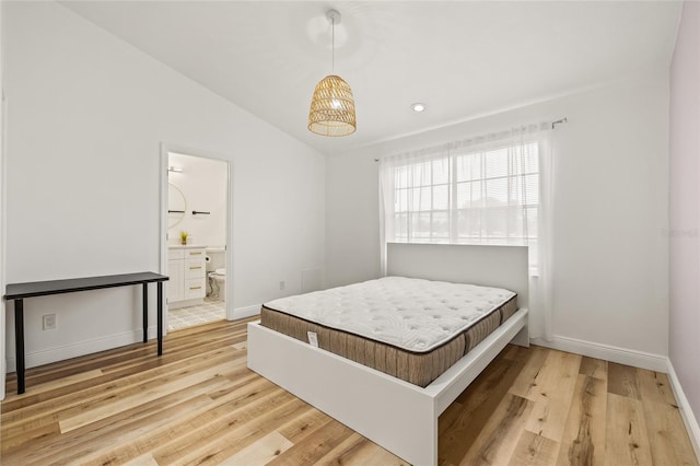 bedroom featuring baseboards, ensuite bathroom, recessed lighting, light wood finished floors, and vaulted ceiling