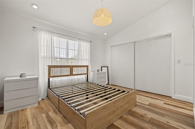 unfurnished bedroom with a closet, recessed lighting, wood finished floors, and vaulted ceiling