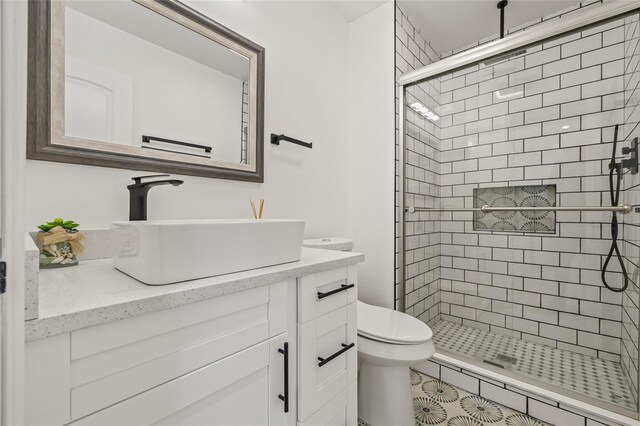bathroom with toilet, a shower stall, and vanity