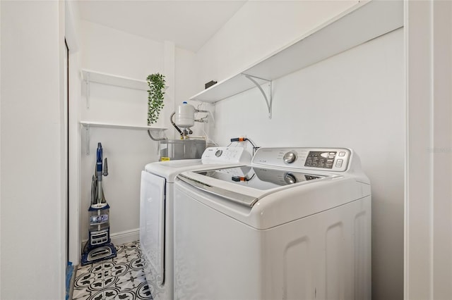 washroom with laundry area, water heater, tile patterned floors, and washer and dryer