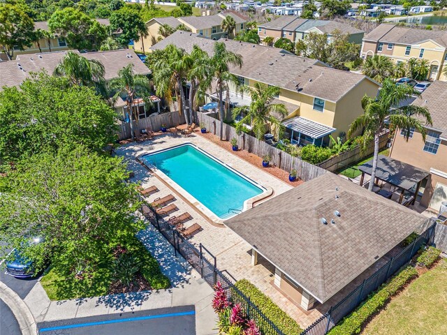 community pool with a residential view and a fenced backyard