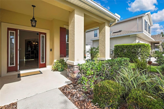 doorway to property featuring a porch and stucco siding