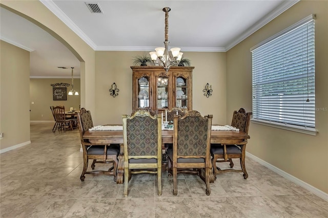 dining room featuring an inviting chandelier, crown molding, visible vents, baseboards, and arched walkways