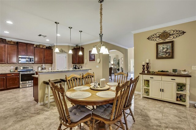 dining space featuring crown molding, arched walkways, recessed lighting, baseboards, and visible vents