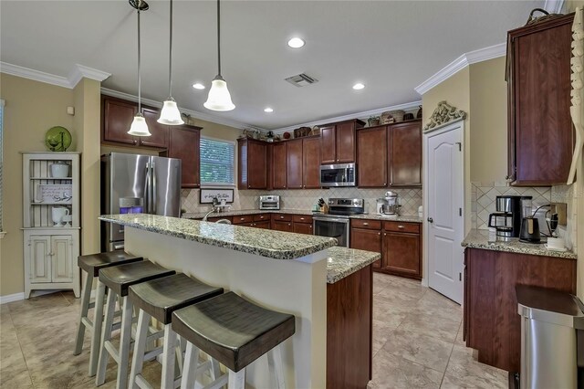 kitchen with backsplash, a kitchen bar, visible vents, crown molding, and stainless steel appliances