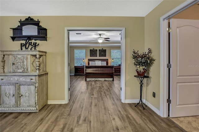 hall with baseboards, wood finished floors, and visible vents