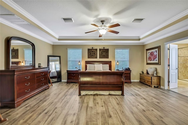 bedroom with crown molding, visible vents, and light wood-type flooring