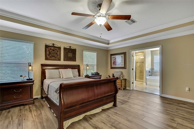 bedroom featuring crown molding, visible vents, multiple windows, and light wood-style floors