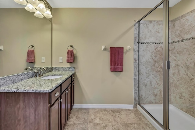 full bath featuring vanity, baseboards, and a stall shower