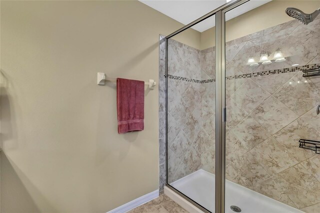 bathroom with baseboards and a stall shower