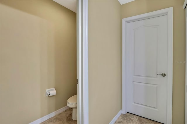 bathroom featuring baseboards and toilet