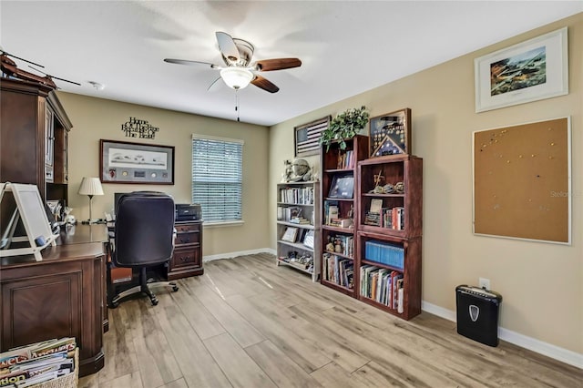 office area featuring light wood-style floors, baseboards, and ceiling fan