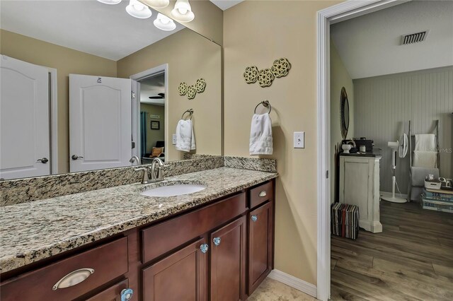 bathroom featuring baseboards, visible vents, wood finished floors, and vanity