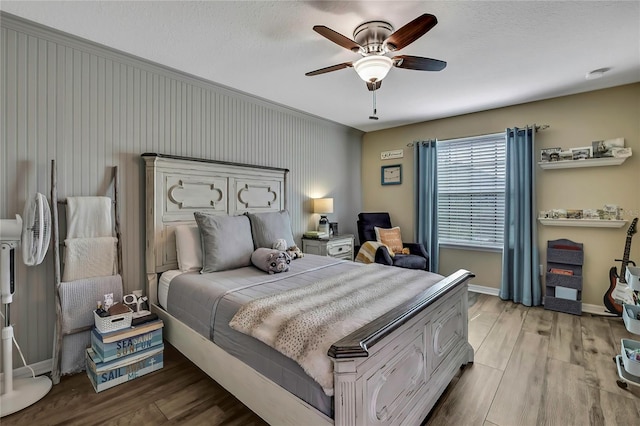 bedroom with baseboards, a ceiling fan, and wood finished floors