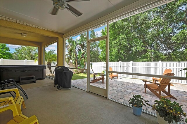 sunroom with ceiling fan and a hot tub
