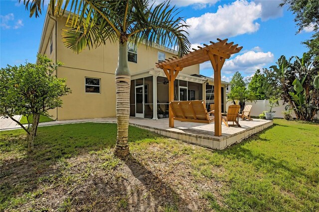 back of property with fence, stucco siding, a sunroom, a patio area, and a lawn