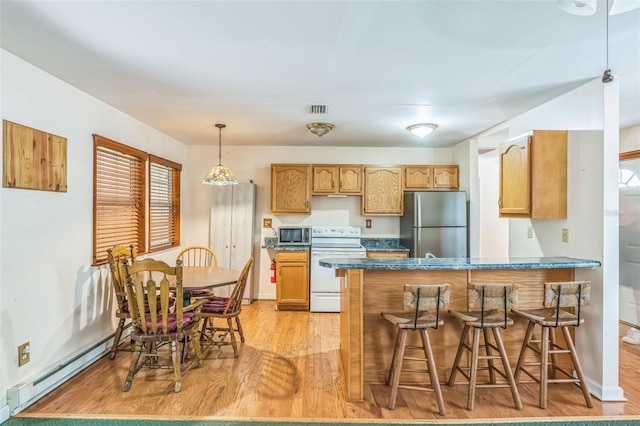 526 Kings Creek Cir, Steinhatchee, FL 32359 - kitchen featuring dark countertops, baseboard heating, light wood-type flooring, a peninsula, and stainless steel appliances
