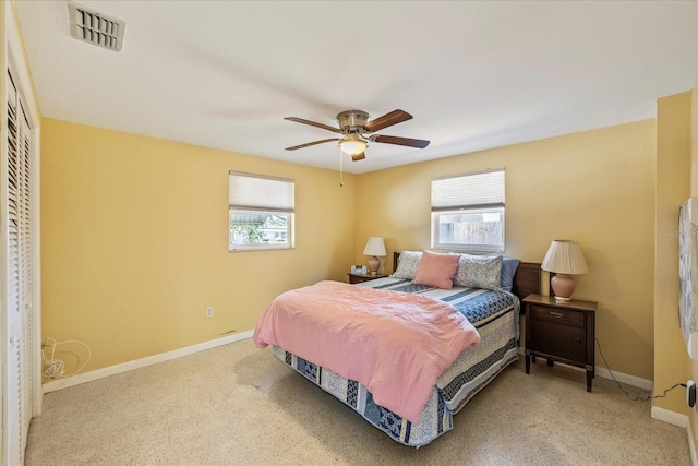 carpeted bedroom featuring baseboards, ceiling fan, a closet, and visible vents