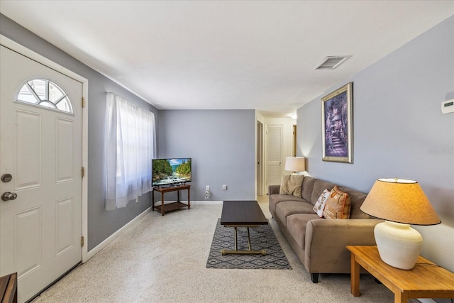 living area with baseboards and visible vents