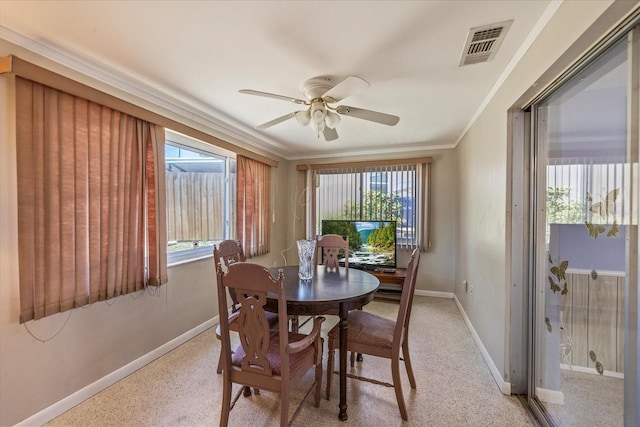 dining space featuring ceiling fan, light colored carpet, visible vents, baseboards, and ornamental molding