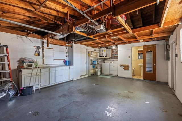 garage featuring separate washer and dryer, gas water heater, and concrete block wall