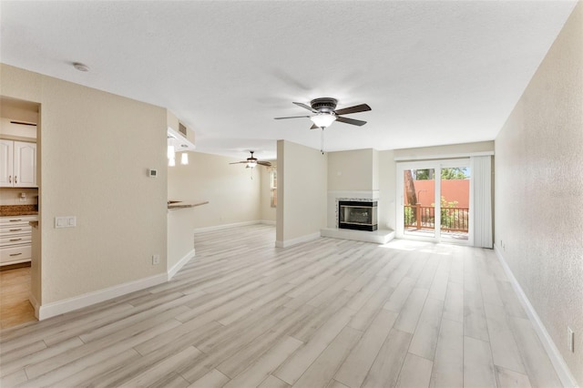 14506 Alejo Ct, Seminole, FL 33776 - unfurnished living room featuring ceiling fan, light wood finished floors, a glass covered fireplace, and baseboards
