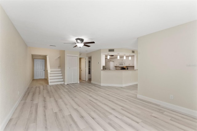 14506 Alejo Ct, Seminole, FL 33776 - unfurnished living room featuring ceiling fan, light wood-type flooring, stairs, and baseboards