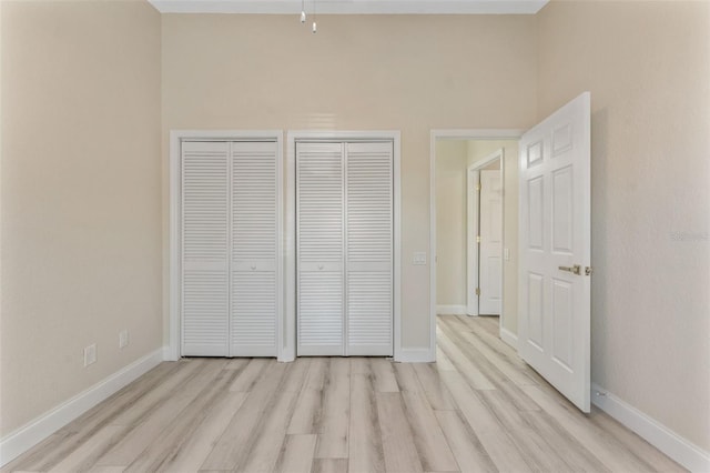 14506 Alejo Ct, Seminole, FL 33776 - unfurnished bedroom with light wood-style flooring, two closets, and baseboards