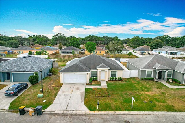 1639 Saddlehorn Dr, Lakeland, FL 33810 - view of front of home featuring a residential view, fence, an attached garage, a front yard, and concrete driveway