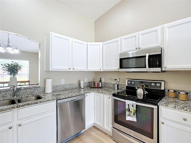 1639 Saddlehorn Dr, Lakeland, FL 33810 - kitchen featuring an inviting chandelier, light stone countertops, white cabinets, a sink, and stainless steel appliances