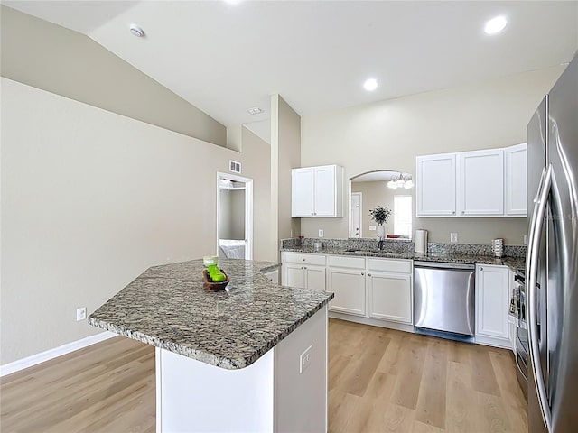 1639 Saddlehorn Dr, Lakeland, FL 33810 - kitchen with appliances with stainless steel finishes, arched walkways, a sink, lofted ceiling, and light wood-style flooring