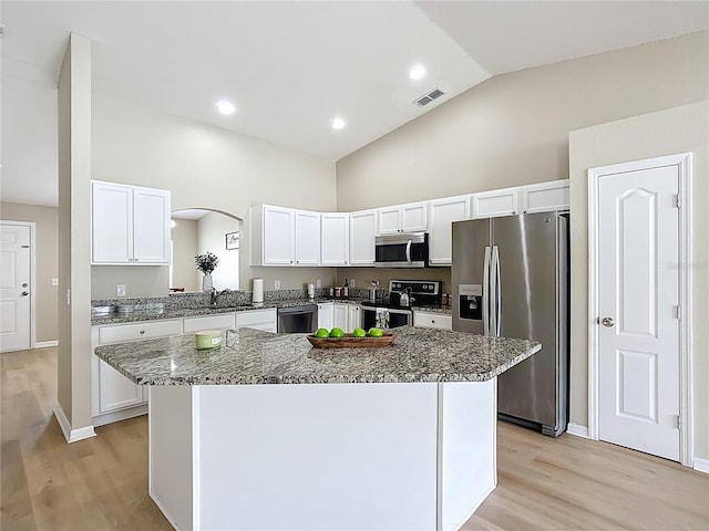 1639 Saddlehorn Dr, Lakeland, FL 33810 - kitchen featuring light wood-type flooring, white cabinets, appliances with stainless steel finishes, and a kitchen island