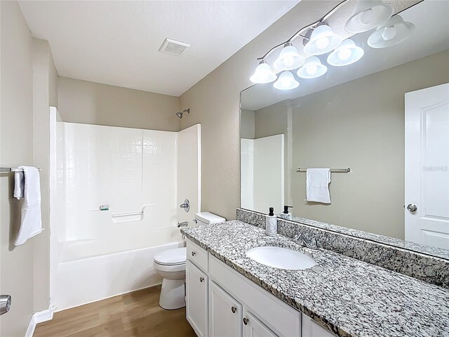 1639 Saddlehorn Dr, Lakeland, FL 33810 - full bath with visible vents, bathtub / shower combination, wood finished floors, vanity, and toilet