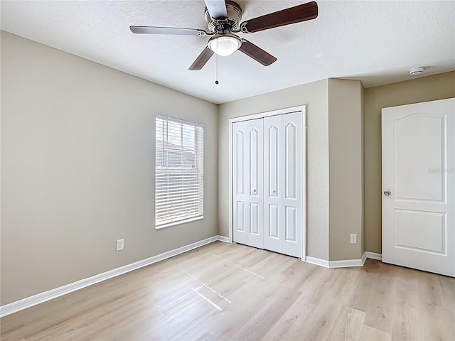 1639 Saddlehorn Dr, Lakeland, FL 33810 - unfurnished bedroom featuring a closet, light wood-style floors, baseboards, ceiling fan, and a textured ceiling