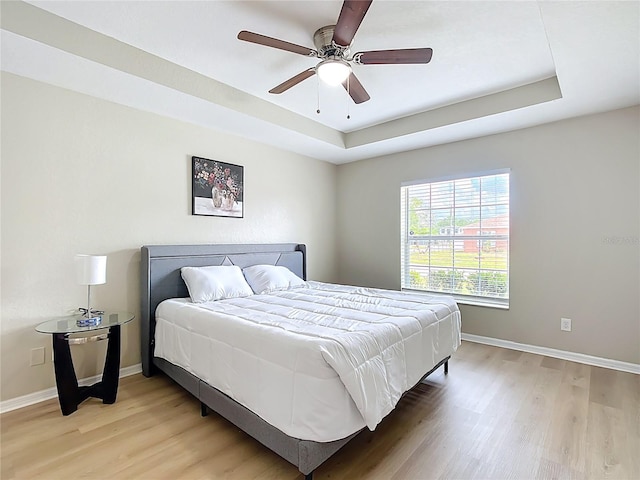 1639 Saddlehorn Dr, Lakeland, FL 33810 - bedroom with baseboards, a tray ceiling, and light wood-type flooring