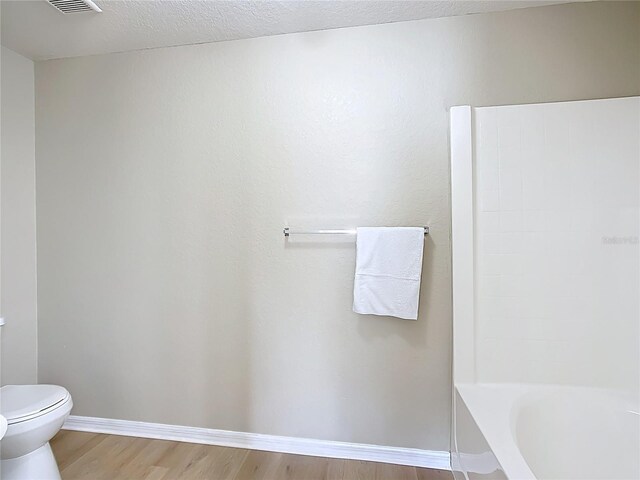 1639 Saddlehorn Dr, Lakeland, FL 33810 - full bathroom with a textured ceiling, visible vents, wood finished floors, baseboards, and toilet