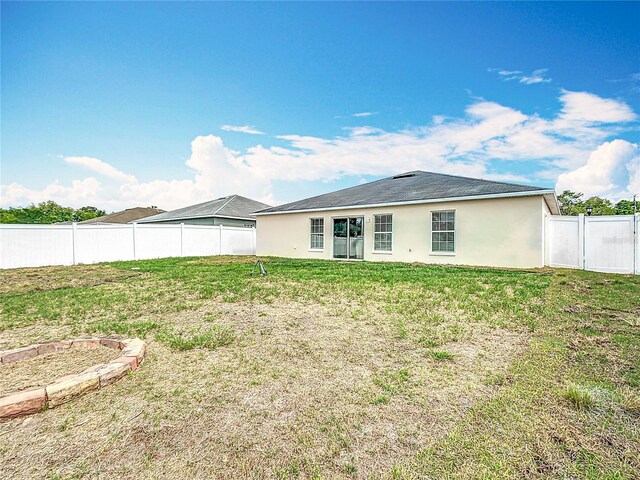 1639 Saddlehorn Dr, Lakeland, FL 33810 - back of property featuring a yard, a fenced backyard, and stucco siding