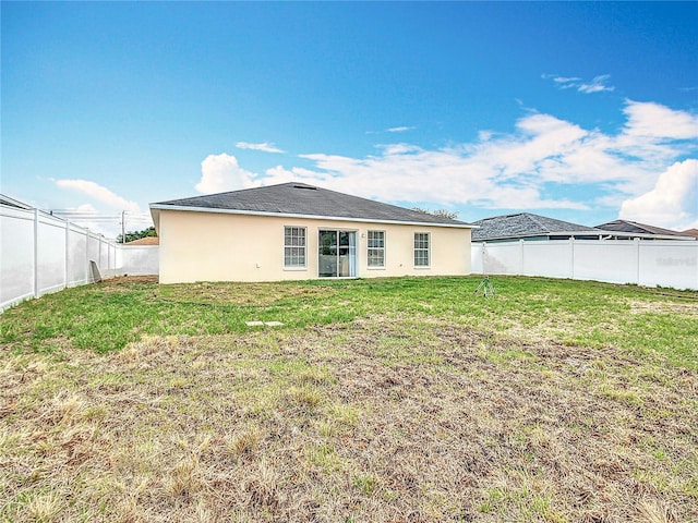 1639 Saddlehorn Dr, Lakeland, FL 33810 - back of property with a fenced backyard, stucco siding, and a lawn