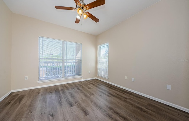 empty room with a ceiling fan, baseboards, and dark wood finished floors