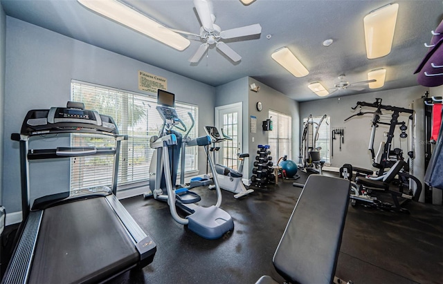 gym featuring baseboards and ceiling fan
