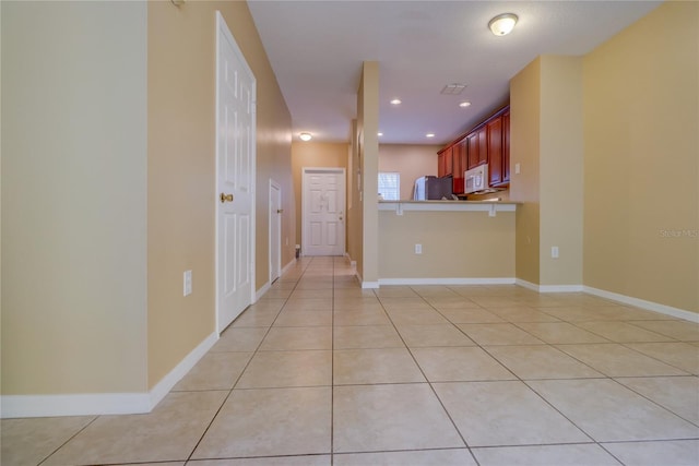 interior space with baseboards, recessed lighting, and light tile patterned flooring
