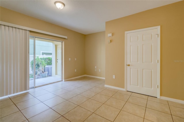 unfurnished room featuring baseboards and light tile patterned flooring