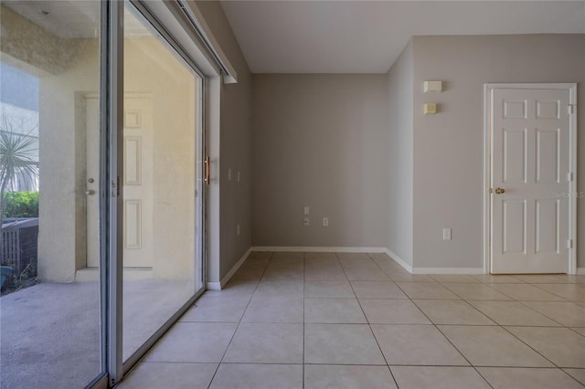 empty room featuring light tile patterned floors and baseboards
